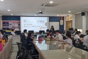 A group of people seated in a room with a projector screen listening to the estate planner presenting.