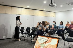 A woman standing in a room with a group of people